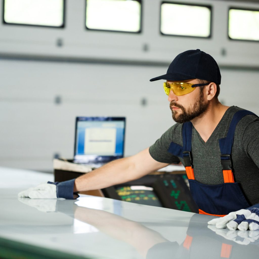 Portrait of worker in overalls, steel factory background.